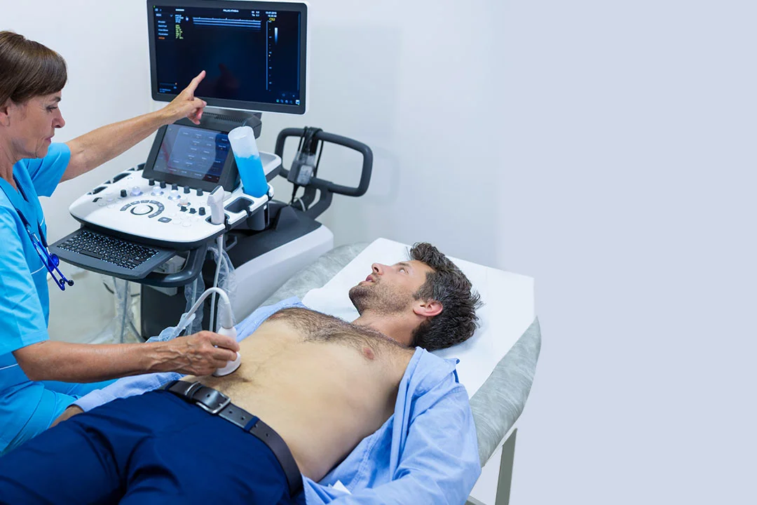 Medical technician using an ultrasound machine to perform a sonography scan on a male patient lying on a hospital bed, clinical room with medical equipment and monitor